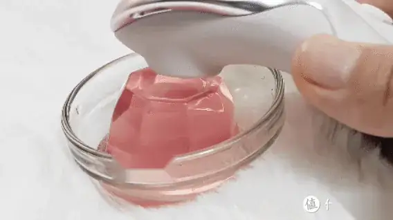 动图:玩具靠近水杯中的粉色液体