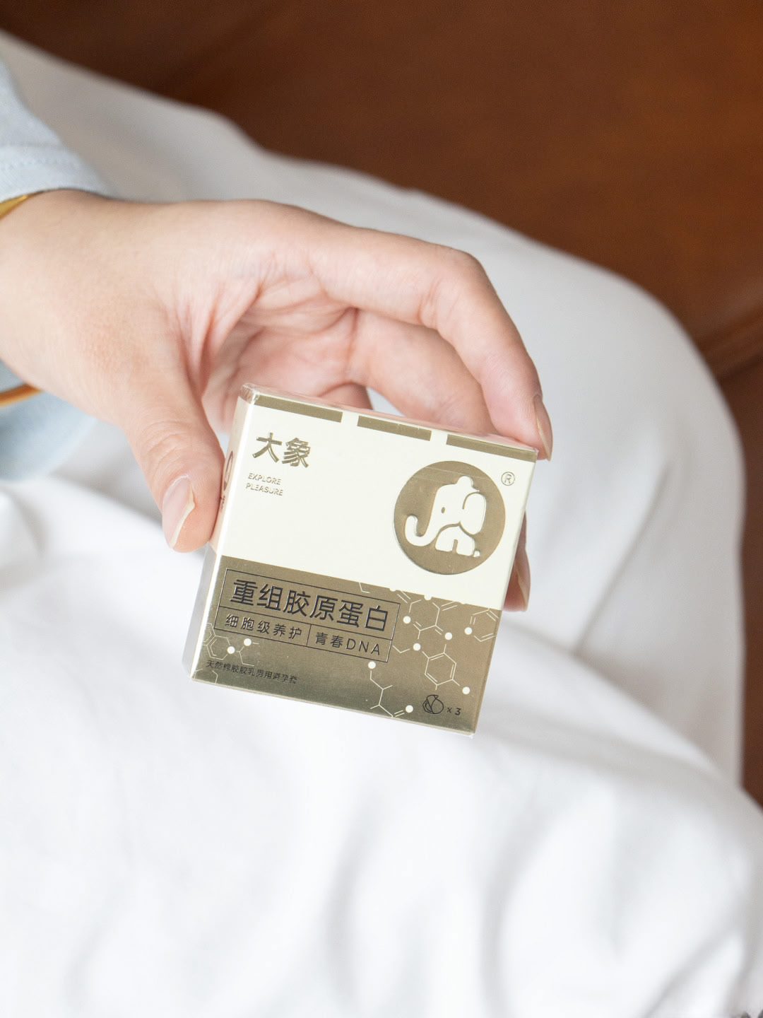 手持大象金色包装盒,盒面印有大象标志与重组胶原蛋白字样