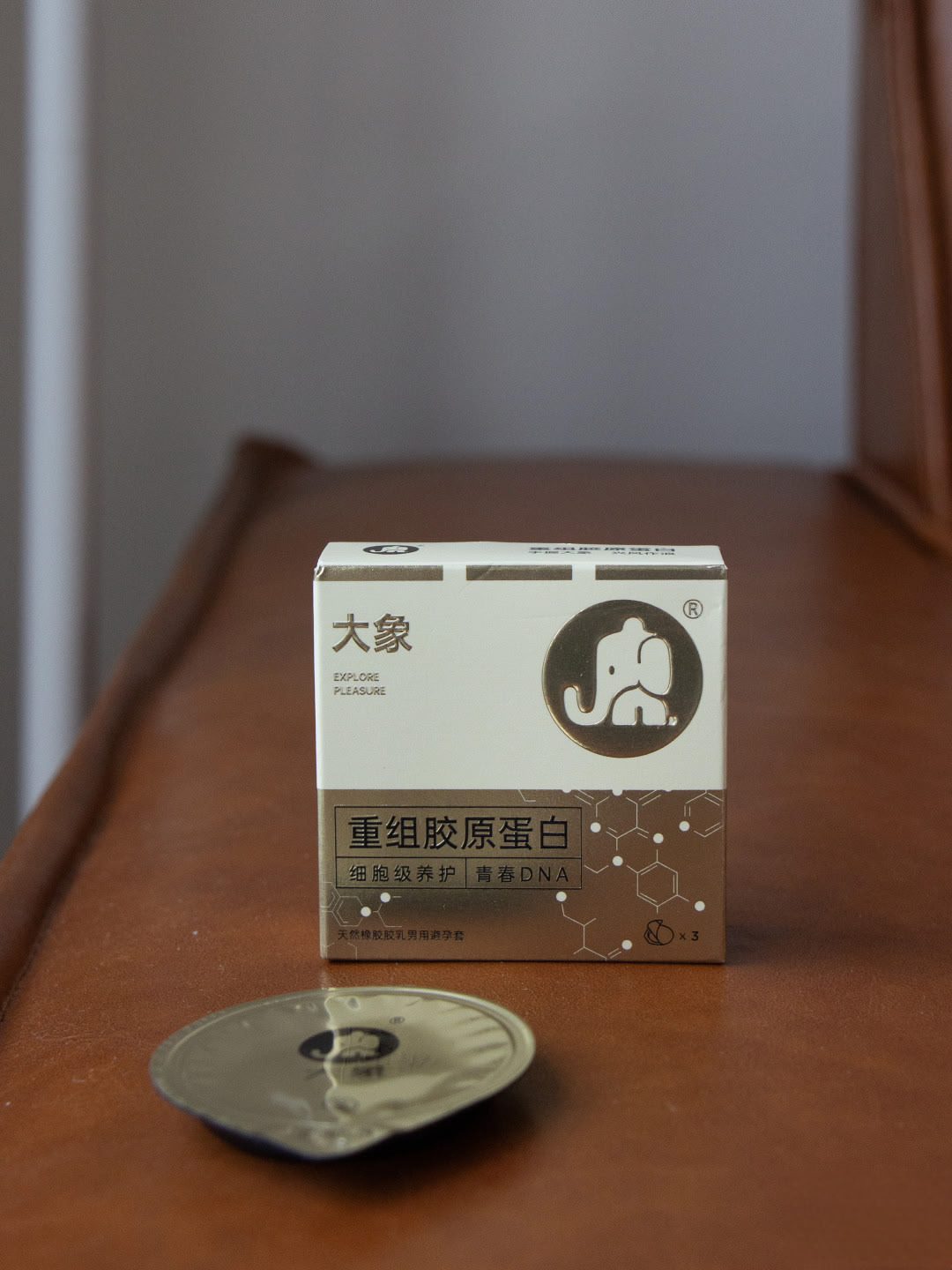 大象包装盒与一枚金色圆罐摆在深色木桌上