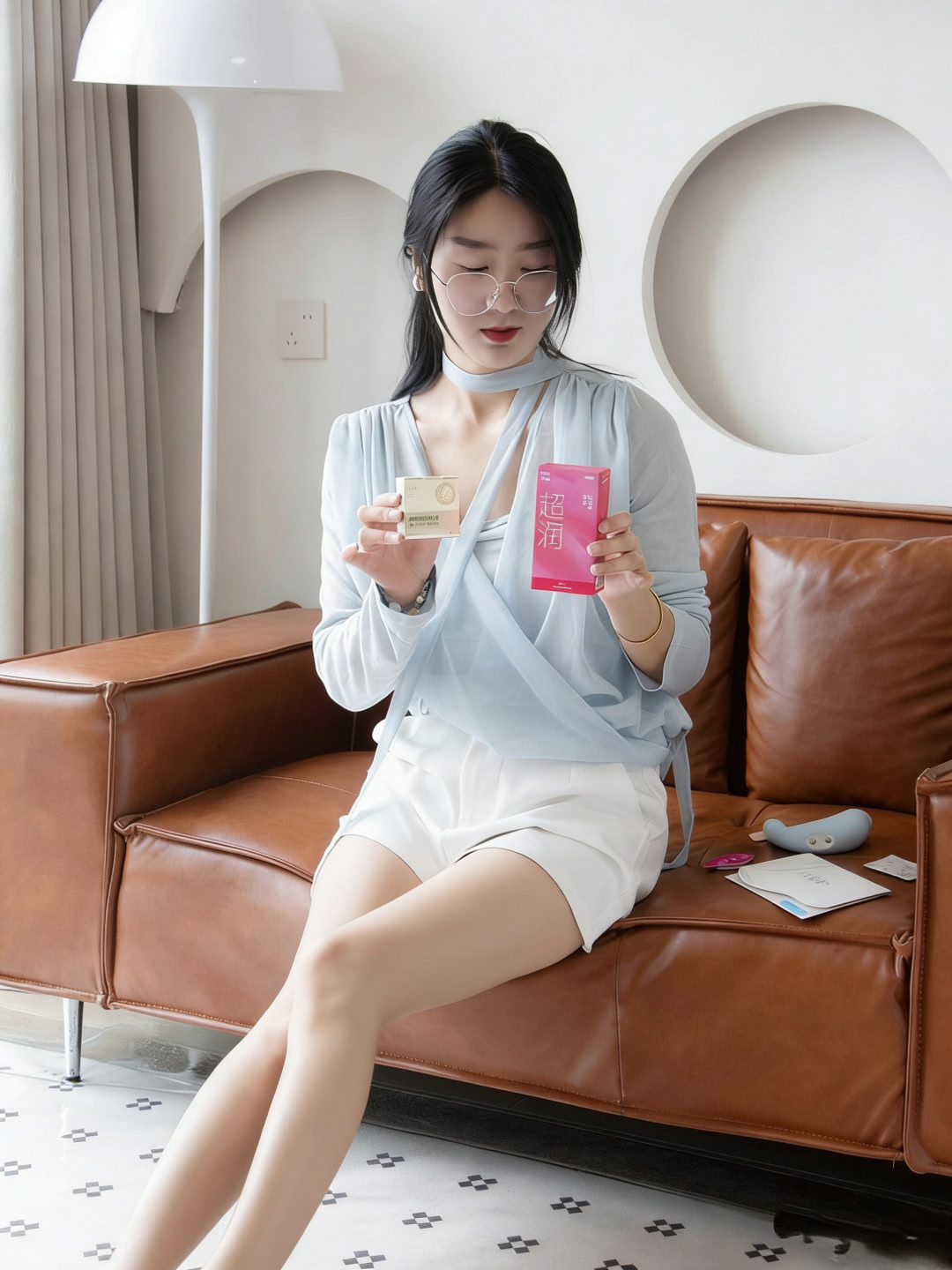 女生坐在棕色皮沙发上,手拿粉色嘟嘟套包装盒