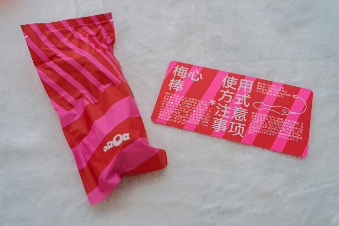 梅心棒单手持握展示:粉白条纹棒身与圆头造型,形似棒棒糖