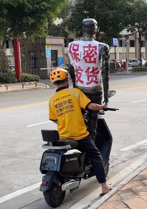 外卖骑手骑着电动车配送保密包裹